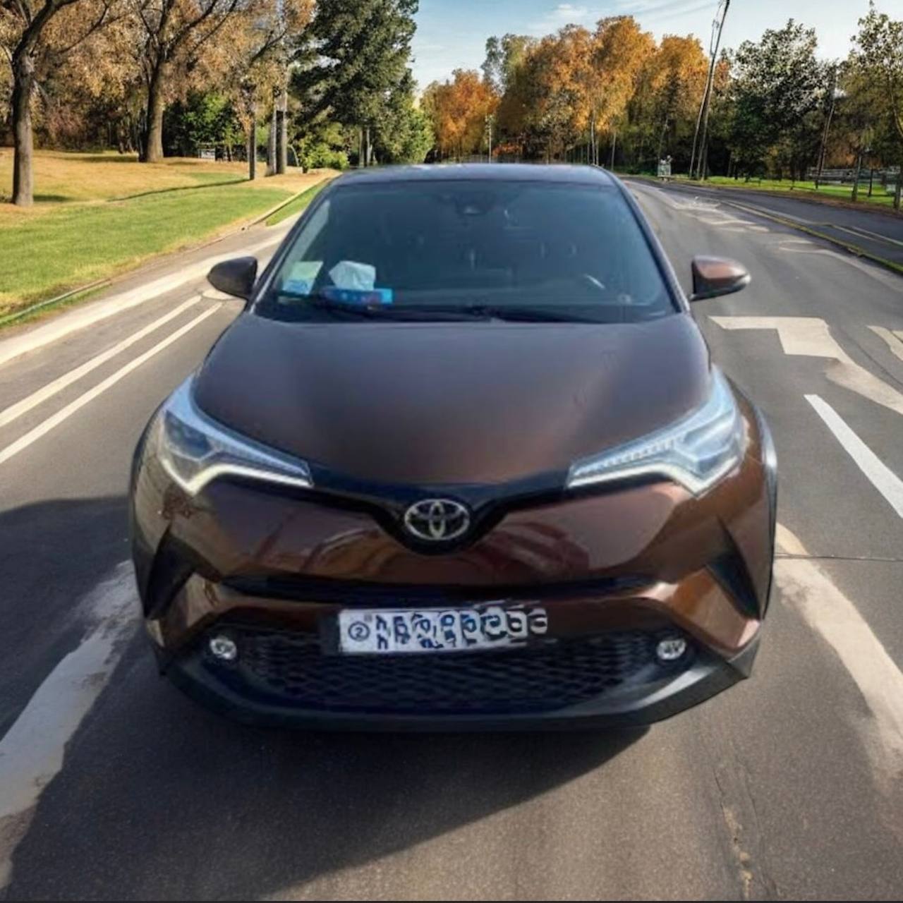 Image of a 2019 Toyota C-HR parked in an urban setting, showcasing its modern design and stylish exterior, emphasizing its subcompact crossover capability.