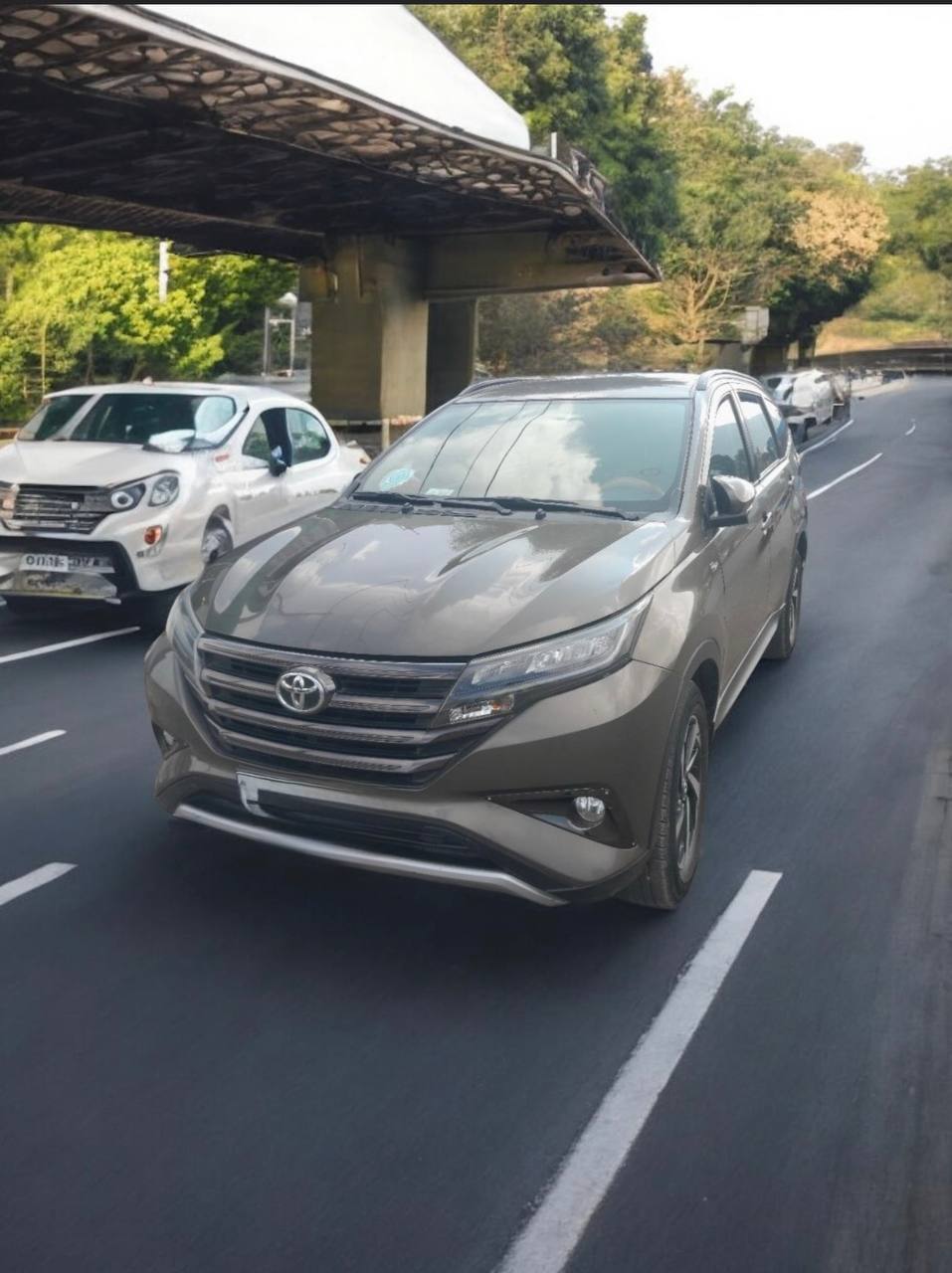 2022 Toyota Rush (GR-S) SUV parked with lush greenery in the background.