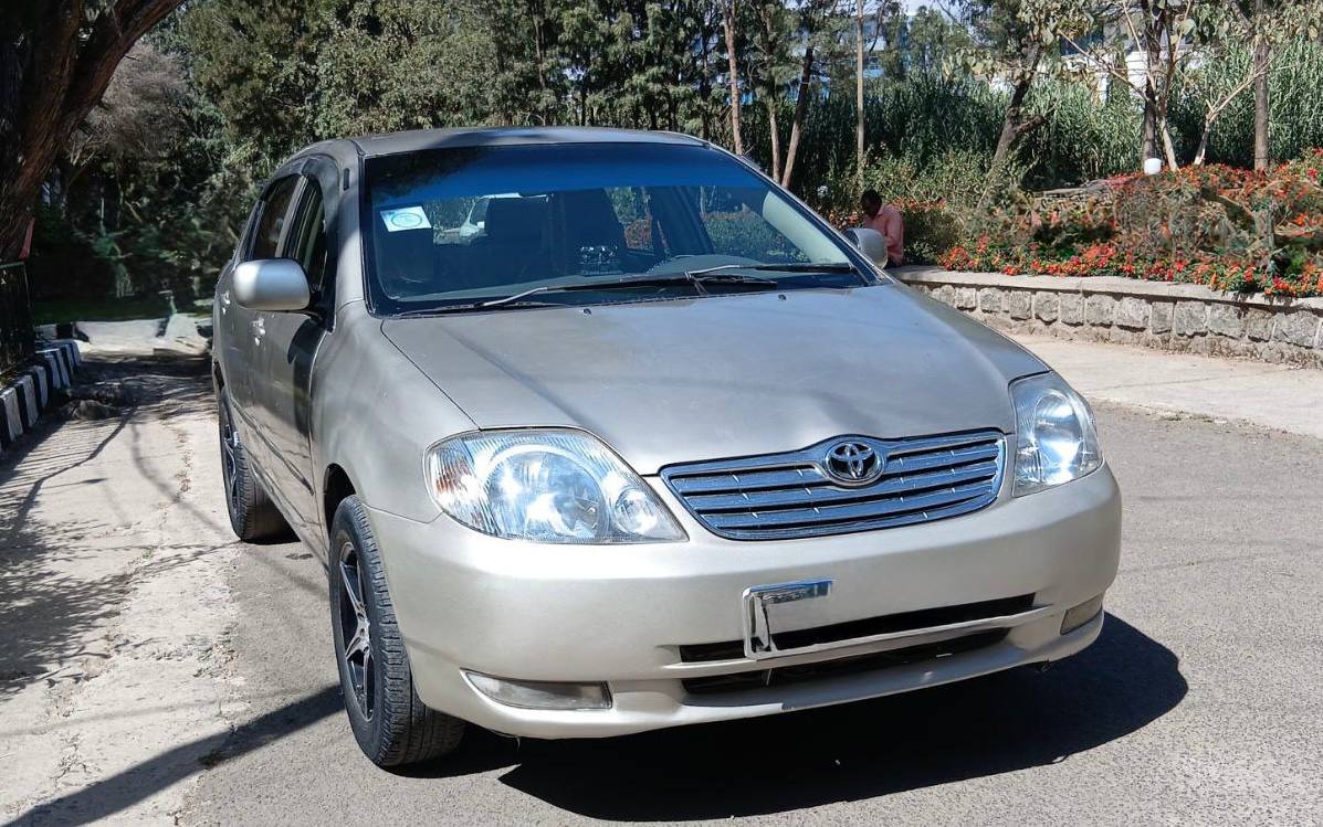 High-quality 2003 Toyota Corolla X front view in sleek Khaki color with Code 2 plates.