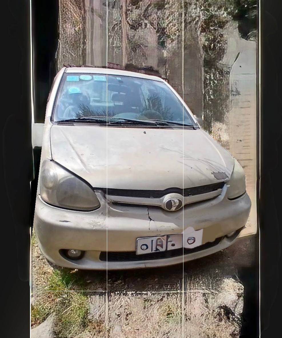 A clean, silver 2003 Toyota Platz XP20 parked on an Addis Ababa street. The photo shows the original factory paint and well-maintained exterior of the vehicle, highlighting its compact and reliable design.